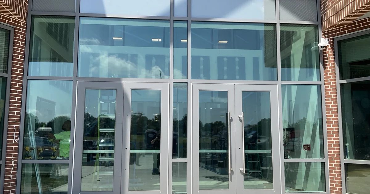 School entrance storefront glazing and aluminum-framed doors during a ballistic-resistant window film retrofit in Milford, Delaware